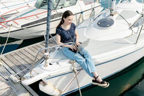 Frau mit laptop auf segelboot