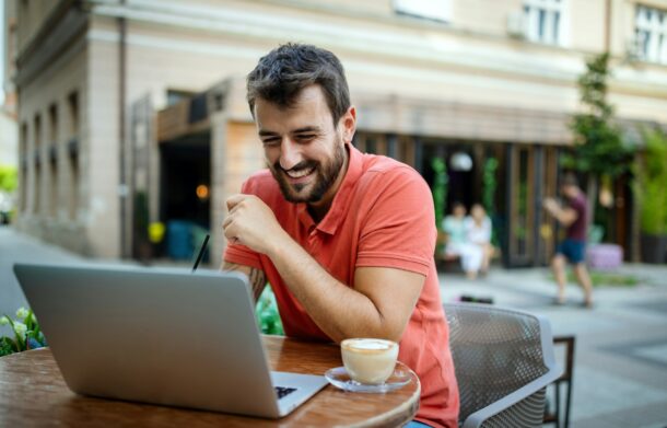 Mann mit Laptop und Cafe